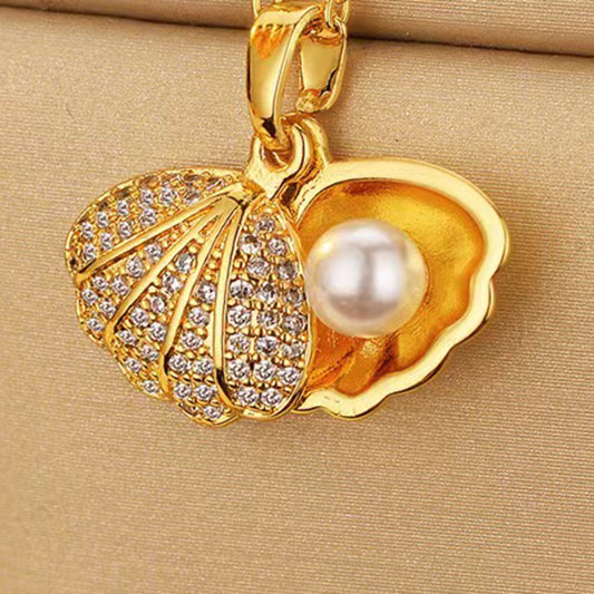 Lilyah Jewelry's 18k Gold plated shell pendant necklace featuring a artificial white pearl and clear rhinestones, displayed on a beige textured background.