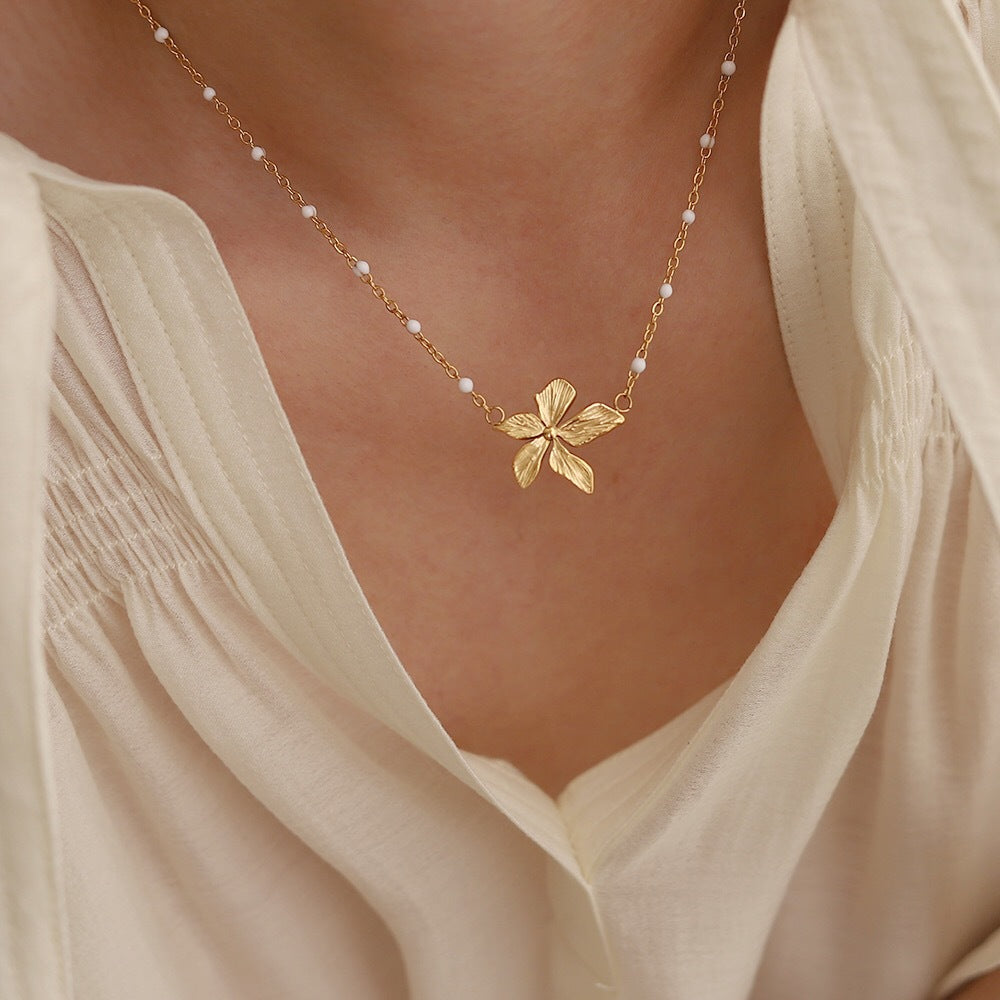 18K Gold Plated necklace with a floral pendant worn by a person in a light-colored top.