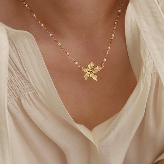 18K Gold Plated necklace with a floral pendant worn by a person in a light-colored top.