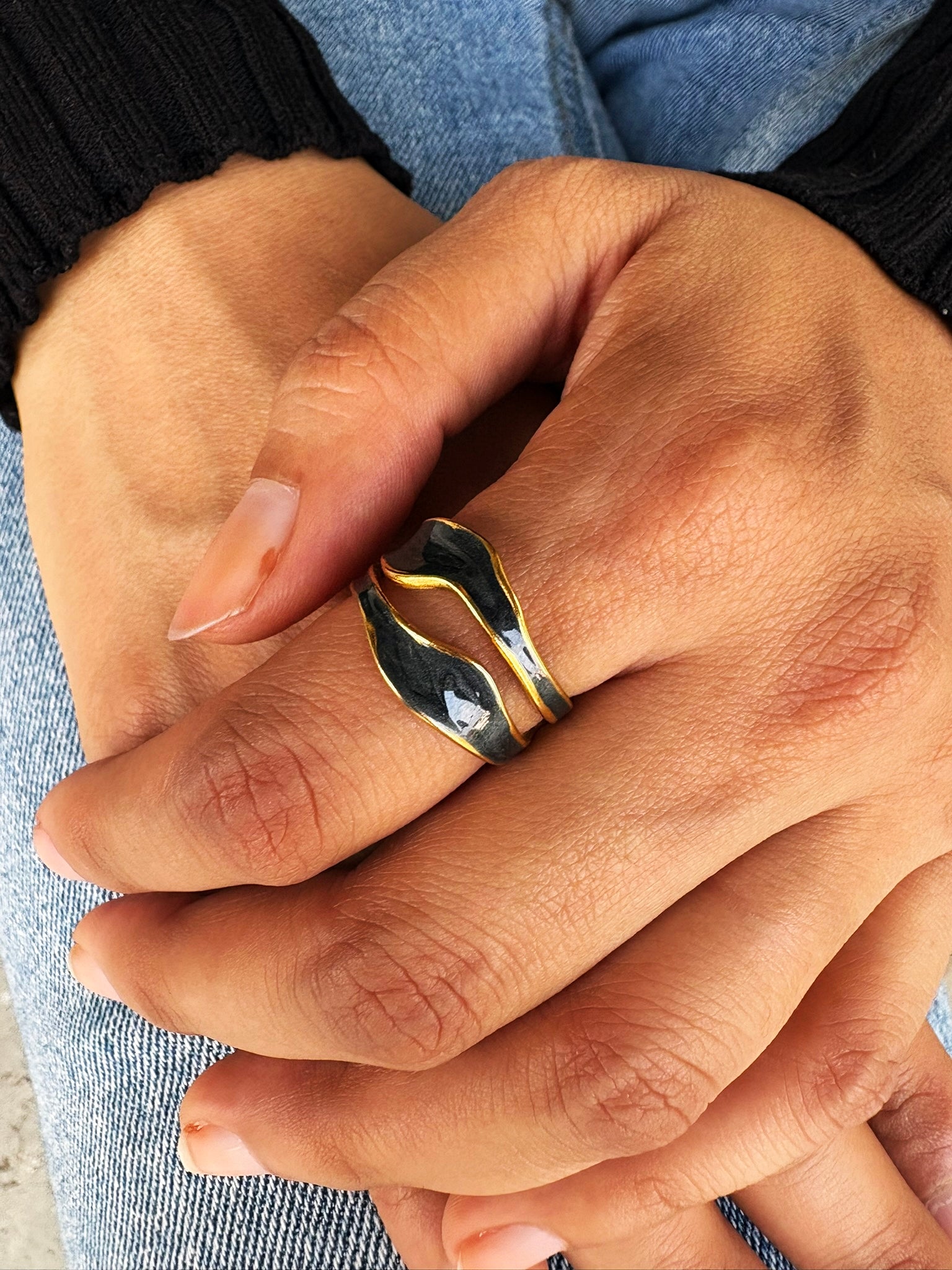 An 18k gold plated midnight pop open ring with a black inlay, displayed on a hand. Lilyah Jewelry Gold Plated Ring . Stunning, minimalistic, adjustable, elegant and statement ring. Gift idea for her.