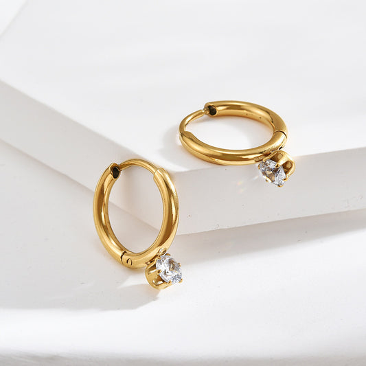 Gold hoop earrings with small diamonds on a white background