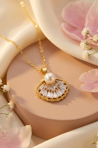 Lilyah Jewelry's 18k gold plated pendant necklace with a white pearl and clear faceted stones, styled on a beige pedestal with soft pink petals and cream satin fabric.