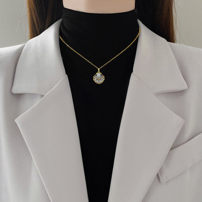 Lilyah Jewelry's 18k Gold plated shell with pearl necklace on a woman with a black turtleneck and light gray blazer