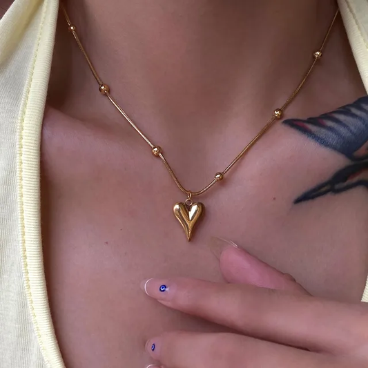 Lilyah Jewelry Necklace. Gold heart-shaped necklace worn by woman.