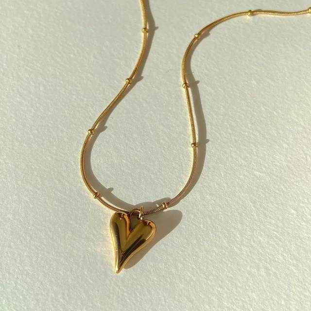 Lilyah Jewelry Necklace. Gold heart-shaped pendant necklace on a light background