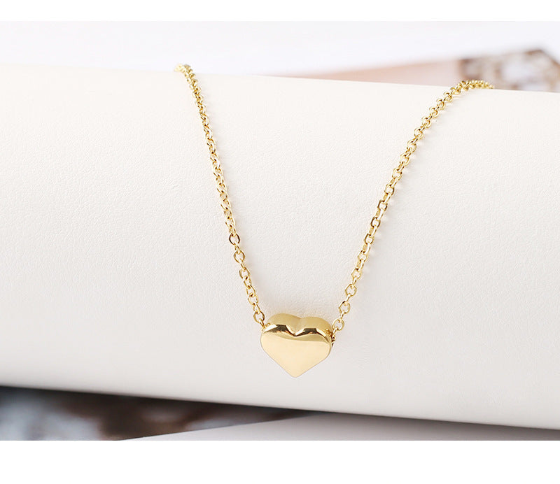 A gold-plated necklace with a minimalistic heart-shaped pendant on a white surface. Lilyah Jewelry Gold Plated Necklace. Gift Ideas for her.