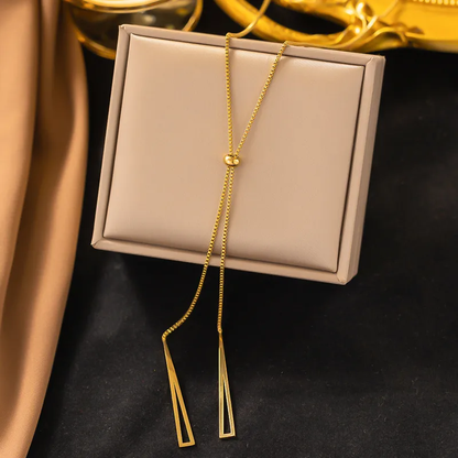 An 18k gold plated y-necklace with a minimalistic design, displayed on a beige box with a reflective surface. Lilyah Jewelry Gold Plated Necklace. Gift Ideas for her.