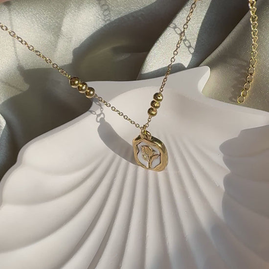 Lilyah Jewelry Necklace video. Under Sunlight. the necklace is golden in colour and has a rose pendant.

