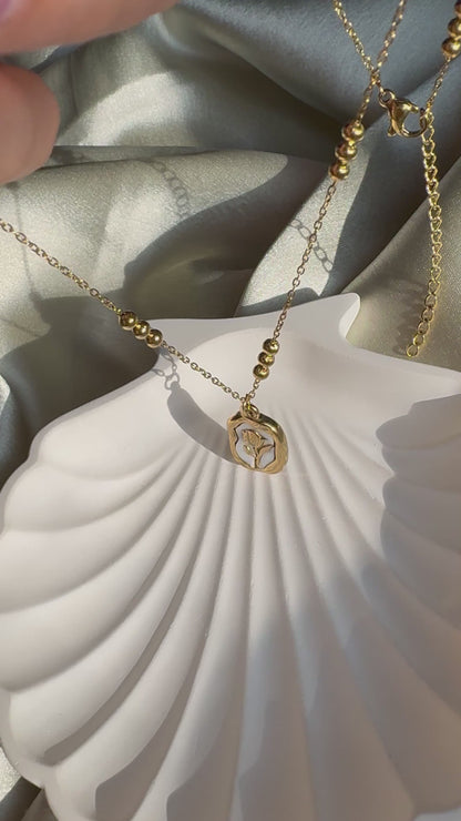 Lilyah Jewelry Necklace video. Under Sunlight. the necklace is golden in colour and has a rose pendant.
